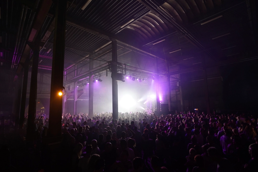 Salle comble sous les lumières violettes