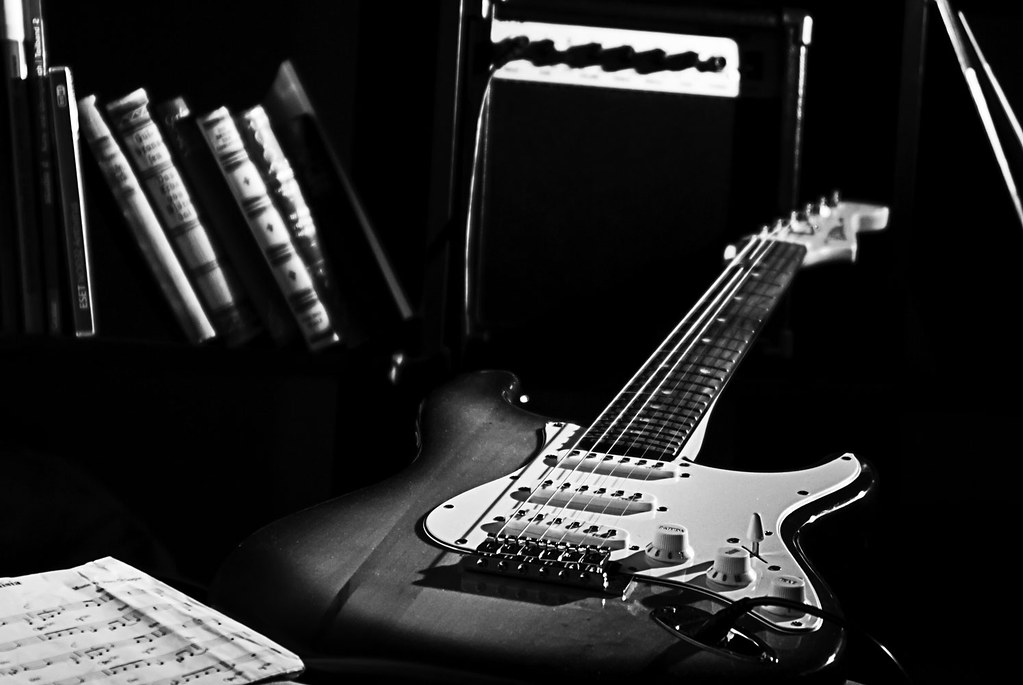 Guitare électrique posée sur un ampli, en noir et blanc